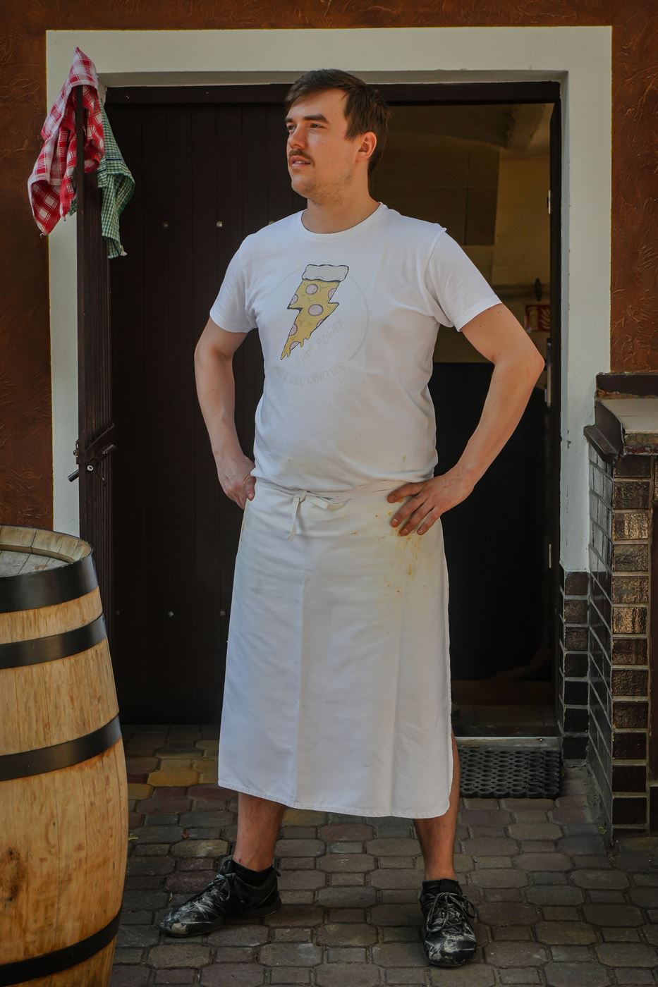 Martin v pizzaiolské zástěře před vchodem do pizzerie