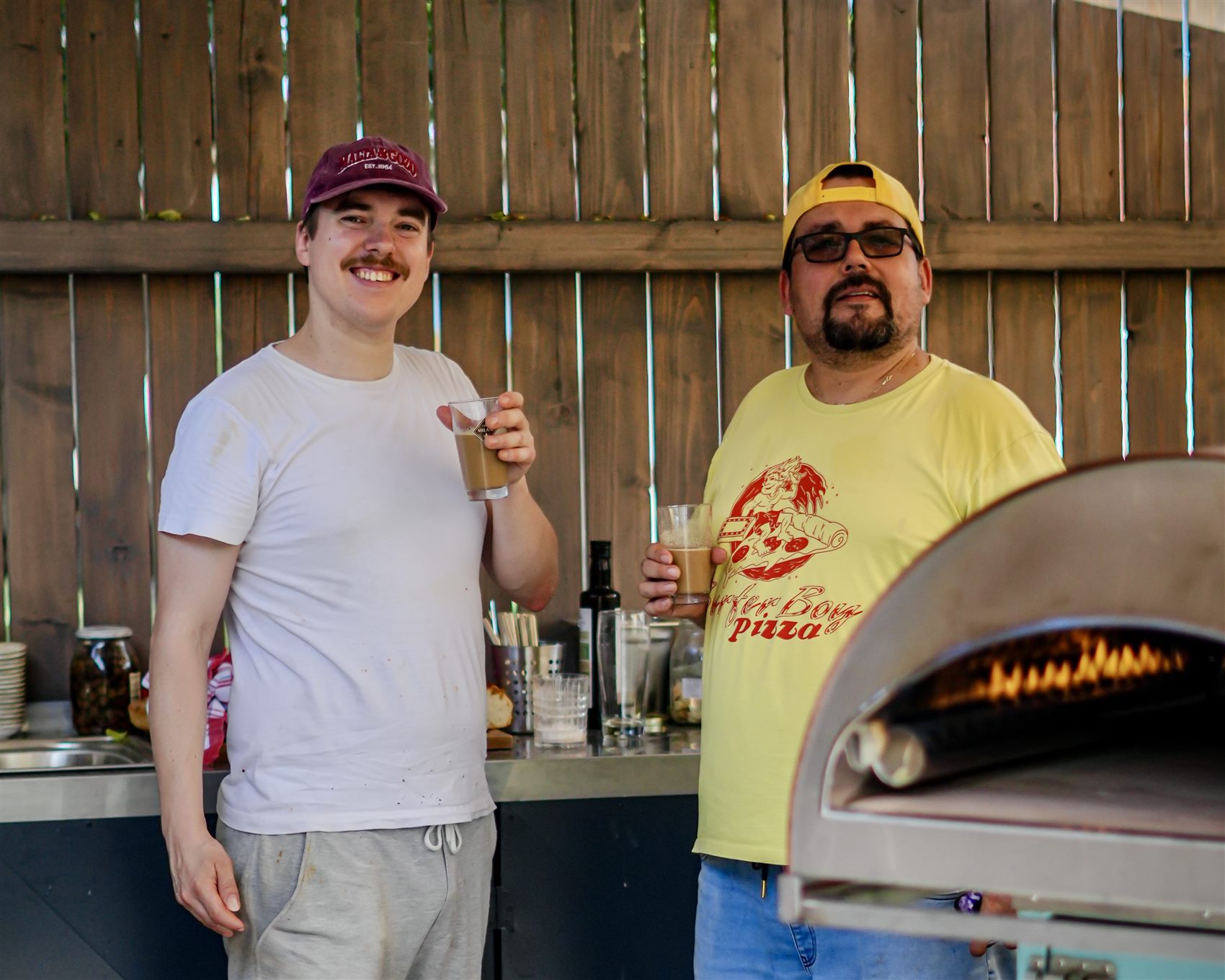 Petr a Martin si připíjejí u pece Per La Pizza